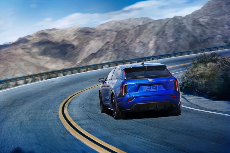 Rear View of a Blue 2026 OPTIQ-V Driving on a Curve of a Mountain Row | Michael Hohl Cadillac in Carson City NV